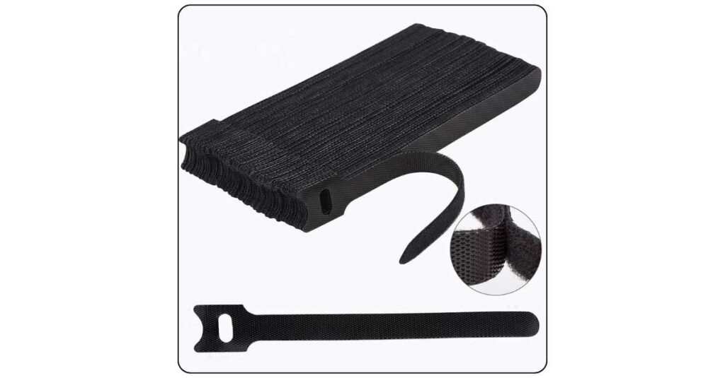 Back edge of college dorm desk with cables neatly bundled with black velcro reusable ties running flat along desk edge toward power strip