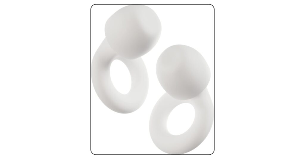 White Loop Quiet 2 reusable earplugs on dorm room nightstand beside bedside caddy with soft ambient lighting and cozy nighttime dorm room in background